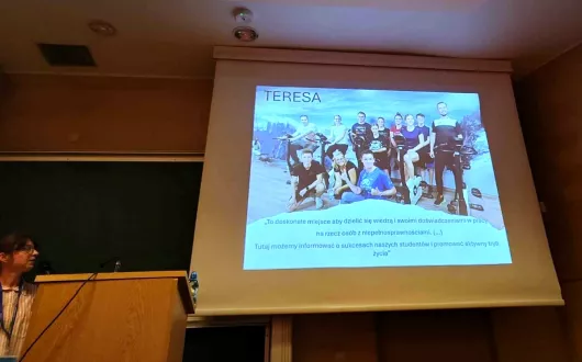 osoba przy ekranie, na którym wyświetlana jest prezentacja 