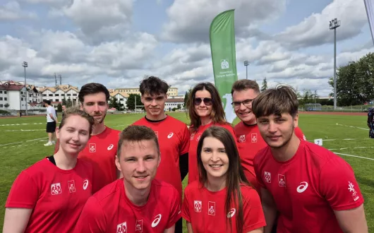 Siedmioro studnetów PŁ z trenerem - wszyscy w czerwnonych koszulkach