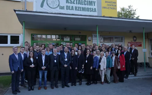 Uczestnicy konferencji pozują przed budynkiem szkoły