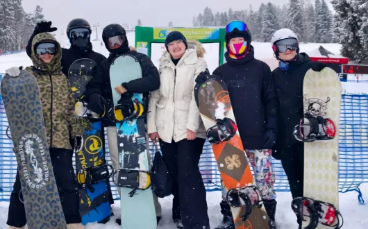 KIlkoro młodych sportowców w strojach narciarskich pozujących do grupowego zdjęcia.