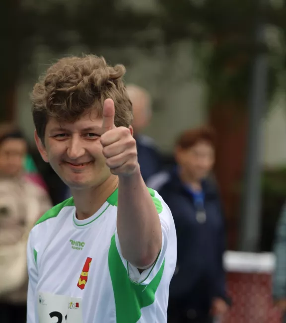 Zawodnik sztafety pokazuje kciuk uniesiony w górę